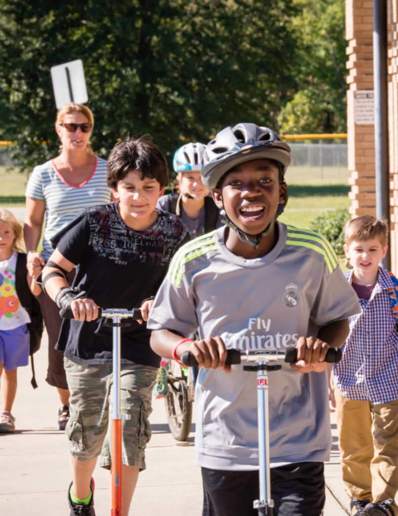 Photo of a diverse group of kids walking and rolling to school.